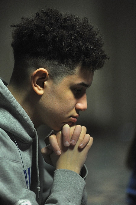 St. Joseph University School student Adrian Lewis prays in a make-shift chapel during 